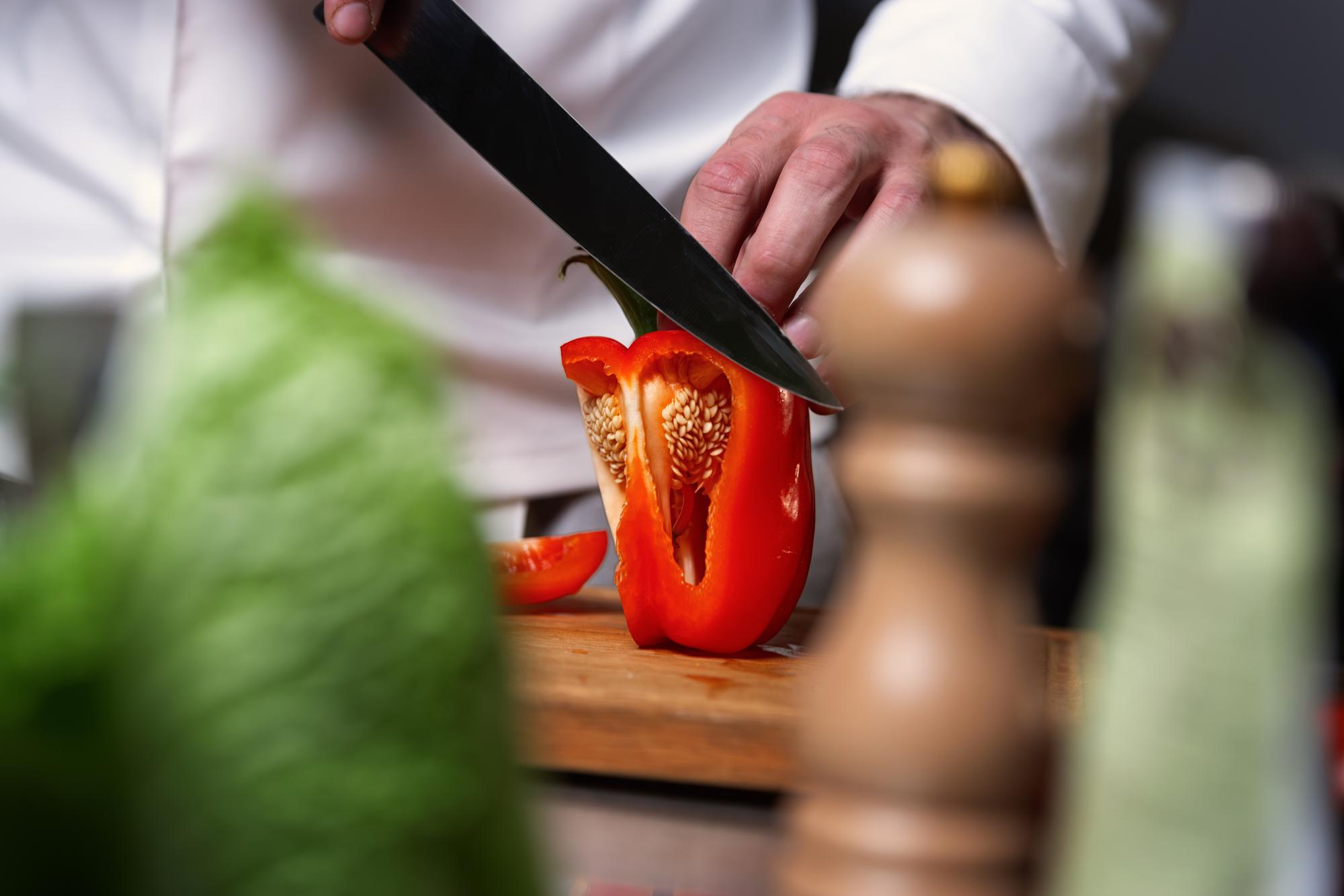 Manos del chef mostrando corte preciso de verduras
