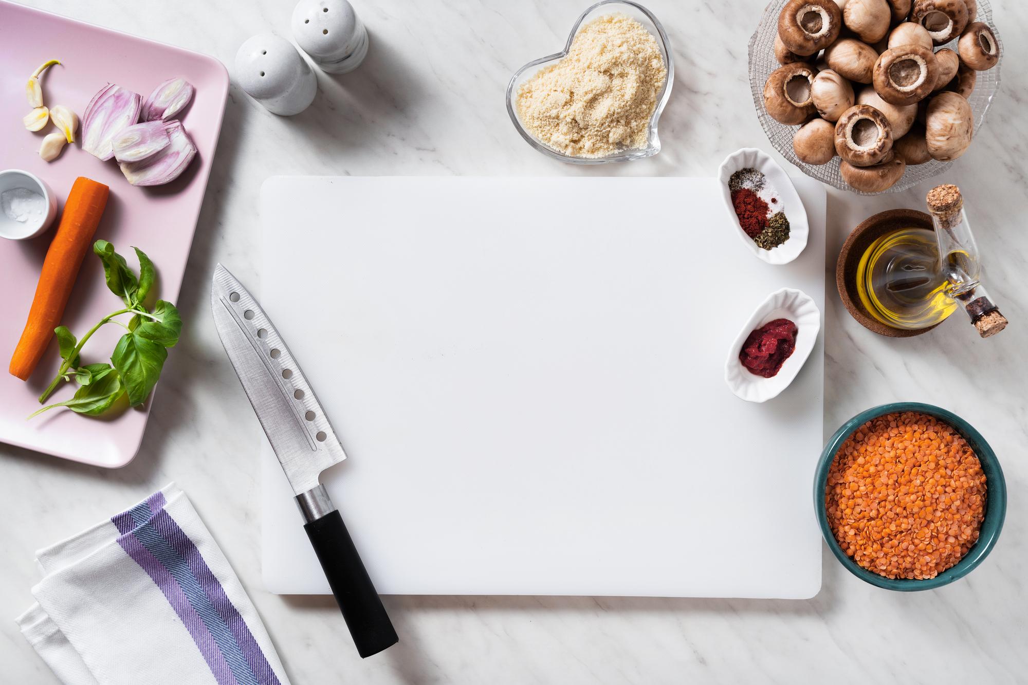 Mesa con ingredientes y cuaderno de recetas